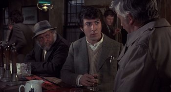Movie still from “Straw Dogs” (1971), directed by Sam Peckinpah – A group of men sitting at a table with drinks; Medium shot, Over the shoulder angle