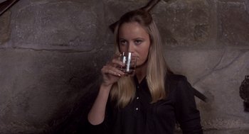 Movie still from “Straw Dogs” (1971), directed by Sam Peckinpah – A woman drinking a glass of water from a cup; Close Up shot, High angle
