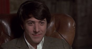 Movie still from “Straw Dogs” (1971), directed by Sam Peckinpah – A person sitting in a chair wearing a suit; Close Up shot, Over the shoulder angle