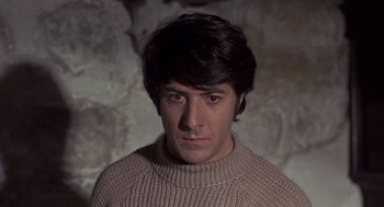 Movie still from “Straw Dogs” (1971), directed by Sam Peckinpah – A man in a sweater stares into the camera; Close Up shot, High angle