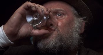 Movie still from “Straw Dogs” (1971), directed by Sam Peckinpah – An old man drinking a glass of wine from a wine glass; Extreme Close Up shot, Low angle