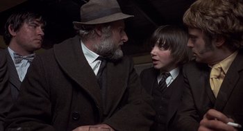 Movie still from “Straw Dogs” (1971), directed by Sam Peckinpah – A man and a young boy talking to each other; Medium shot, Over the shoulder angle