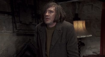 Movie still from “Straw Dogs” (1971), directed by Sam Peckinpah – A man with long hair and a brown jacket; Medium shot, Low angle