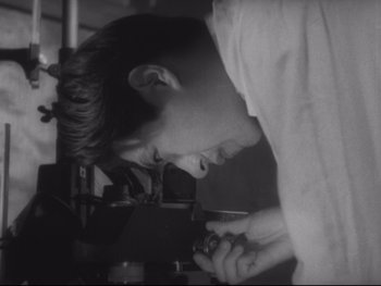 Movie still from “Stray Dog” (1949), directed by Akira Kurosawa – A young man looking down at a piece of metal; Extreme Close Up shot, High angle