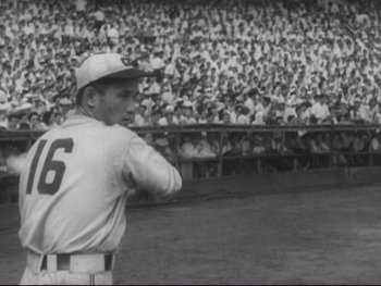 Movie still from “Stray Dog” (1949), directed by Akira Kurosawa – An old photo of a baseball player in front of an audience; Medium shot, Low angle