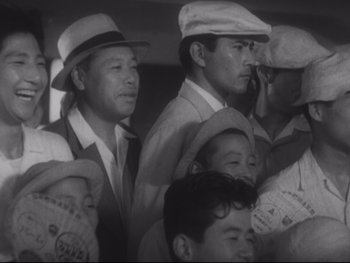 Movie still from “Stray Dog” (1949), directed by Akira Kurosawa – Black and white photograph of men in hats and ties; Medium shot, High angle