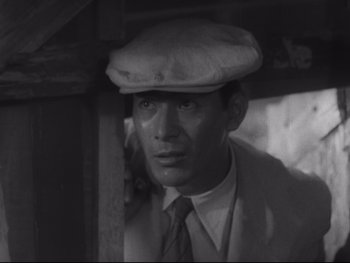Movie still from “Stray Dog” (1949), directed by Akira Kurosawa – A black and white photo of a man wearing a hat; Close Up shot, Low angle