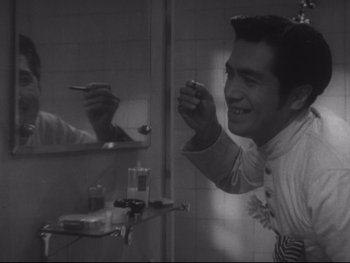 Movie still from “Stray Dog” (1949), directed by Akira Kurosawa – A man brushing his teeth in front of a bathroom mirror; Close Up shot, Low angle