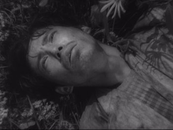 Movie still from “Stray Dog” (1949), directed by Akira Kurosawa – A black and white photo of a man laying in the grass; Close Up shot, High angle
