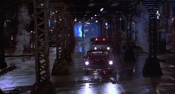 Movie still from “Streets of Fire” (1984), directed by Walter Hill – A group of cars driving down a street at night; Extreme Wide shot, High angle