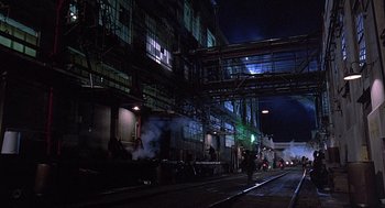 Movie still from “Streets of Fire” (1984), directed by Walter Hill – A train station at night with steam coming out of it; Extreme Wide shot, Low angle