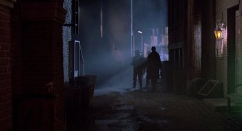 Movie still from “Streets of Fire” (1984), directed by Walter Hill – A group of people standing in a dark alley; Wide shot, Low angle