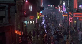 Movie still from “Streets of Fire” (1984), directed by Walter Hill – A crowd of people walking down a street at night; Extreme Wide shot, High angle