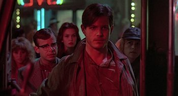 Movie still from “Streets of Fire” (1984), directed by Walter Hill – A group of people standing in a dark room; Close Up shot, Over the shoulder angle
