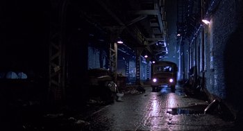 Movie still from “Streets of Fire” (1984), directed by Walter Hill – A bus is driving down the street at night; Extreme Wide shot, Low angle