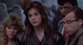 Movie still from “Streets of Fire” (1984), directed by Walter Hill – A woman in a leather jacket is looking at the camera; Close Up shot, Over the shoulder angle