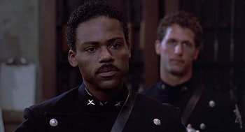 Movie still from “Streets of Fire” (1984), directed by Walter Hill – A man in a black uniform and a man in a black uniform; Close Up shot, Low angle