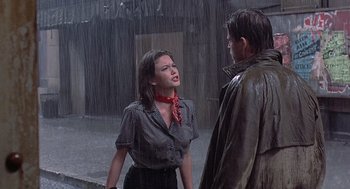 Movie still from “Streets of Fire” (1984), directed by Walter Hill – A man and a woman standing in the pouring rain; Medium shot, Over the shoulder angle