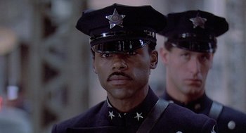 Movie still from “Streets of Fire” (1984), directed by Walter Hill – A man in a police officer's uniform with a star on his hat; Close Up shot, Low angle