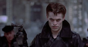 Movie still from “Streets of Fire” (1984), directed by Walter Hill – A man in a black leather jacket holding a gun; Close Up shot, Low angle