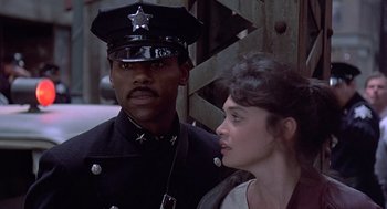 Movie still from “Streets of Fire” (1984), directed by Walter Hill – A police officer standing next to a woman in uniform; Close Up shot, Over the shoulder angle