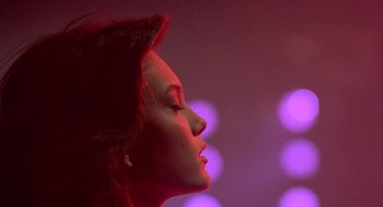 Movie still from “Streets of Fire” (1984), directed by Walter Hill – A woman's face in front of purple lights; Close Up shot, Low angle