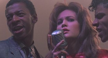 Movie still from “Streets of Fire” (1984), directed by Walter Hill – A man and a woman sing into a microphone; Close Up shot, Low angle