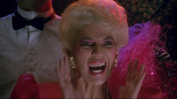 Movie still from “Strictly Ballroom” (1992), directed by Baz Luhrmann – An older woman with blonde hair and a big smile on her face; Close Up shot, Low angle