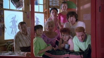 Movie still from “Strictly Ballroom” (1992), directed by Baz Luhrmann – A group of people that are sitting in a room together; Medium shot, High angle