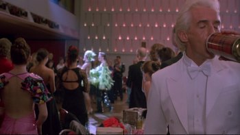 Movie still from “Strictly Ballroom” (1992), directed by Baz Luhrmann – A group of people dressed up in costumes at an event; Medium shot, Over the shoulder angle