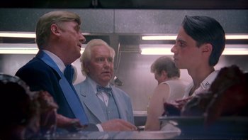 Movie still from “Strictly Ballroom” (1992), directed by Baz Luhrmann – A group of people standing around in a kitchen; Close Up shot, Over the shoulder angle