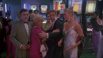 Movie still from “Strictly Ballroom” (1992), directed by Baz Luhrmann – A group of people standing in a room; Medium shot, Over the shoulder angle
