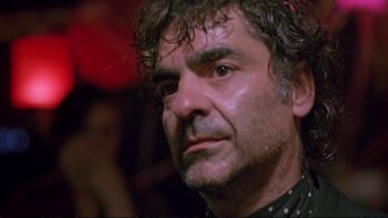 Movie still from “Strictly Ballroom” (1992), directed by Baz Luhrmann – A person with curly hair; Close Up shot, Low angle