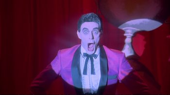 Movie still from “Strictly Ballroom” (1992), directed by Baz Luhrmann – A person wearing a suit and tie; Medium shot, Low angle