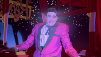 Movie still from “Strictly Ballroom” (1992), directed by Baz Luhrmann – A man in a purple jacket and a black bow tie; Medium shot, Low angle