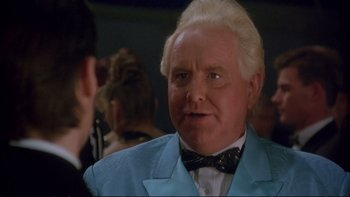 Movie still from “Strictly Ballroom” (1992), directed by Baz Luhrmann – An older man in a blue suit and a bow tie; Close Up shot, Over the shoulder angle