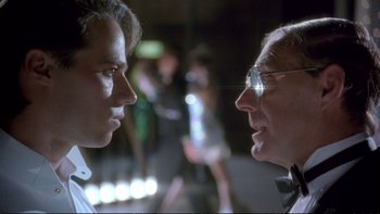 Movie still from “Strictly Ballroom” (1992), directed by Baz Luhrmann – Two men are facing each other in front of a crowd; Close Up shot, Over the shoulder angle