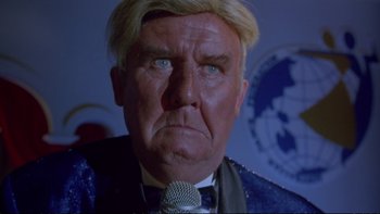 Movie still from “Strictly Ballroom” (1992), directed by Baz Luhrmann – An older man with a microphone in his mouth; Close Up shot, Low angle