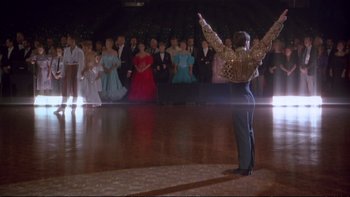 Movie still from “Strictly Ballroom” (1992), directed by Baz Luhrmann – A group of people in formal wear standing on a dance floor; Wide shot, Low angle