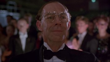 Movie still from “Strictly Ballroom” (1992), directed by Baz Luhrmann – A man in a suit and bow tie wearing glasses; Close Up shot, Low angle