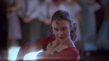 Movie still from “Strictly Ballroom” (1992), directed by Baz Luhrmann – A woman in a red dress is holding a light; Close Up shot, Low angle