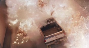 Movie still from “Striking Distance” (1993), directed by Rowdy Herrington – An old pickup truck is in the middle of a fire; Extreme Wide shot, Overhead angle