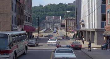 Movie still from “Striking Distance” (1993), directed by Rowdy Herrington – Cars driving down a street in a city; Extreme Wide shot, High angle