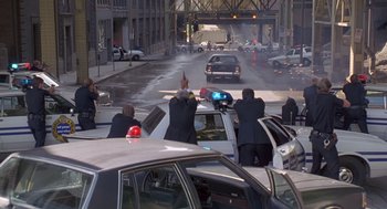 Movie still from “Striking Distance” (1993), directed by Rowdy Herrington – A group of people riding in cars down a street; Extreme Wide shot, High angle