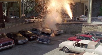 Movie still from “Striking Distance” (1993), directed by Rowdy Herrington – A car that has been set on fire by a fire hydrant; Extreme Wide shot, High angle