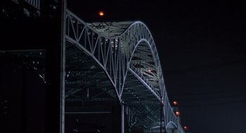 Movie still from “Striking Distance” (1993), directed by Rowdy Herrington – A bridge that has some lights in the sky above it; Extreme Wide shot, Low angle