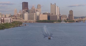 Movie still from “Striking Distance” (1993), directed by Rowdy Herrington – A large body of water in front of a city skyline; Extreme Wide shot, High angle