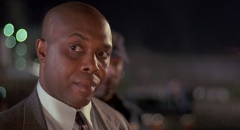 Movie still from “Striking Distance” (1993), directed by Rowdy Herrington – A person wearing a suit and tie; Close Up shot, Low angle