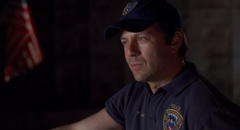 Movie still from “Striking Distance” (1993), directed by Rowdy Herrington – A man in a police uniform with a hat on; Close Up shot, Low angle