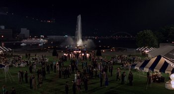 Movie still from “Striking Distance” (1993), directed by Rowdy Herrington – A group of people standing in a field at night; Extreme Wide shot, High angle